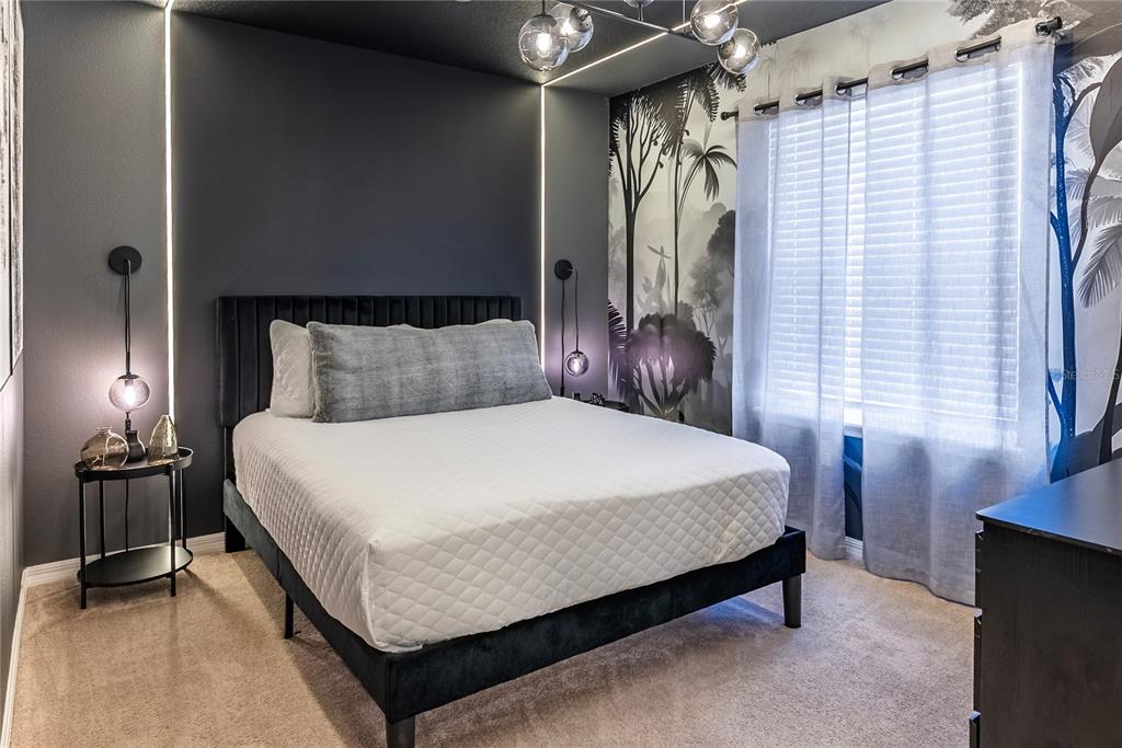 4425 Kaipo Road Davenport, FL 33897 - Photo 53 of 100 a bed sitting in a bedroom next to a window and a lamp