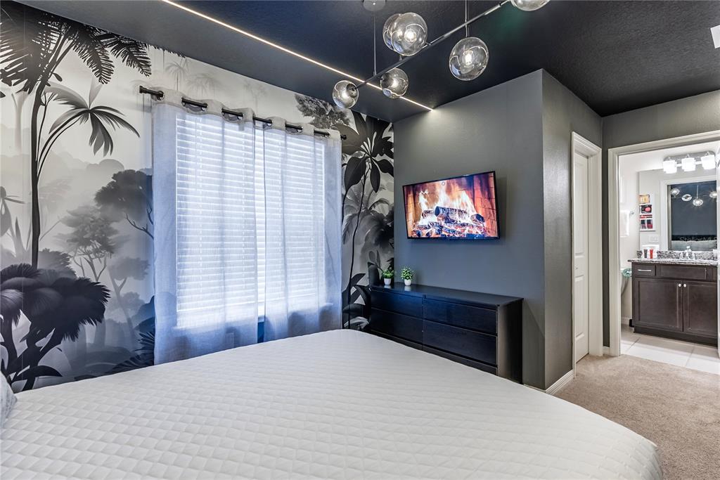 4425 Kaipo Road Davenport, FL 33897 - Photo 56 of 100 a bedroom with a bed and a chandelier