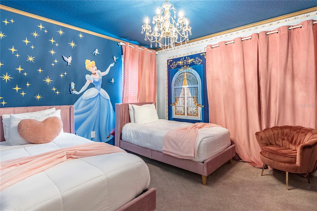 4425 Kaipo Road Davenport, FL 33897 - Photo 69 of 100 a bedroom with two beds and a chandelier