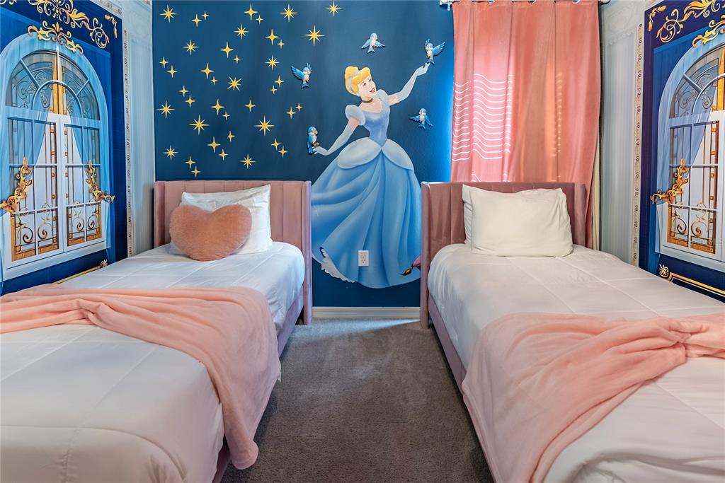 4425 Kaipo Road Davenport, FL 33897 - Photo 70 of 100 a bedroom with a large bed and a chandelier