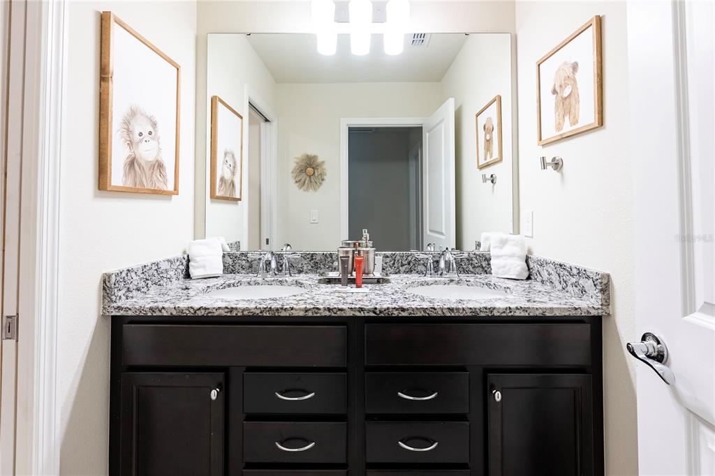 4425 Kaipo Road Davenport, FL 33897 - Photo 71 of 100 a bathroom with a granite countertop sink and a mirror