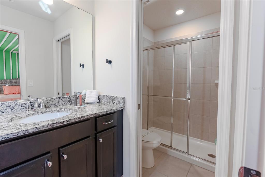 4425 Kaipo Road Davenport, FL 33897 - Photo 81 of 100 a bathroom with a granite countertop sink a toilet and shower