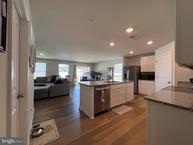 a living room with stainless steel appliances furniture and a view of kitchen