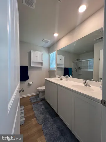 a bathroom with a double vanity sink toilet and mirror