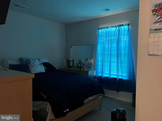 a bed sitting in a bedroom next to a window