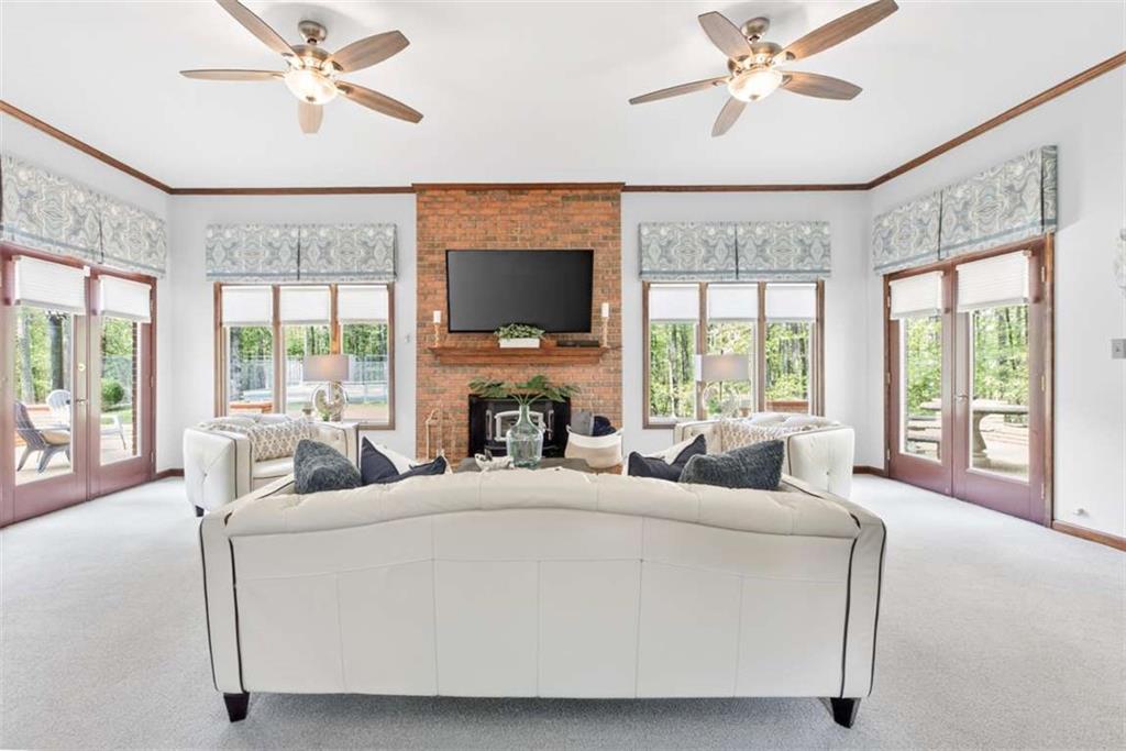 3035 Mt Zion Road Oxford, GA 30054 - Photo 31 of 99 a living room with fireplace furniture large window and a flat screen tv