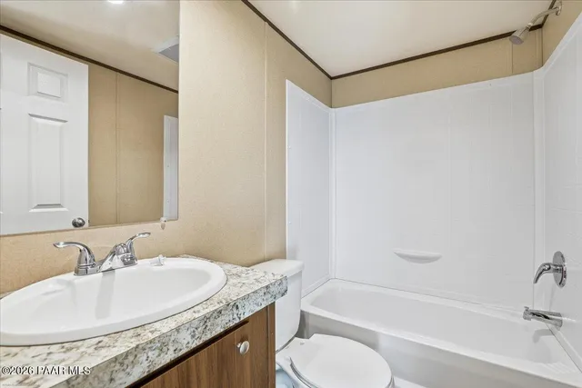 a bathroom with a granite countertop sink a toilet and bathtub