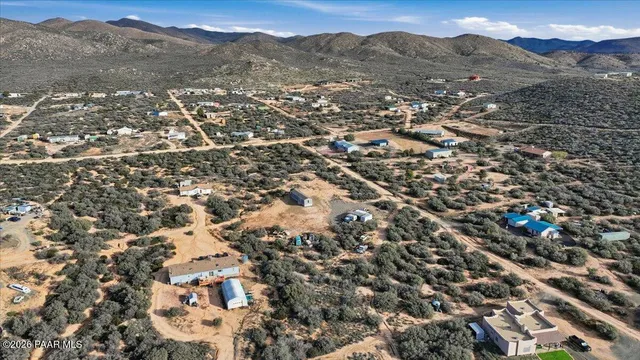 an aerial view of residential houses with outdoor space and trees