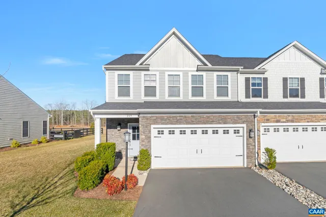 a view of a white house with a large space in front of it