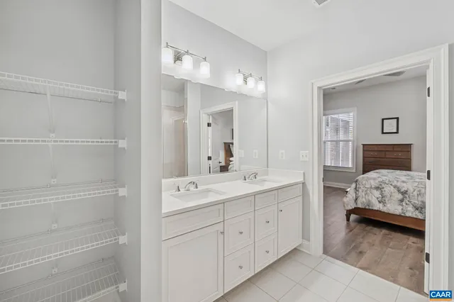 a spacious bathroom with a double vanity sink mirror and shower