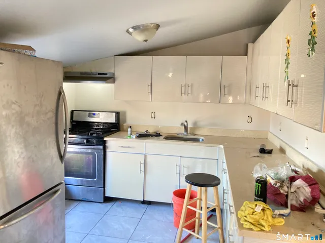 a kitchen with stainless steel appliances a stove a sink and a refrigerator