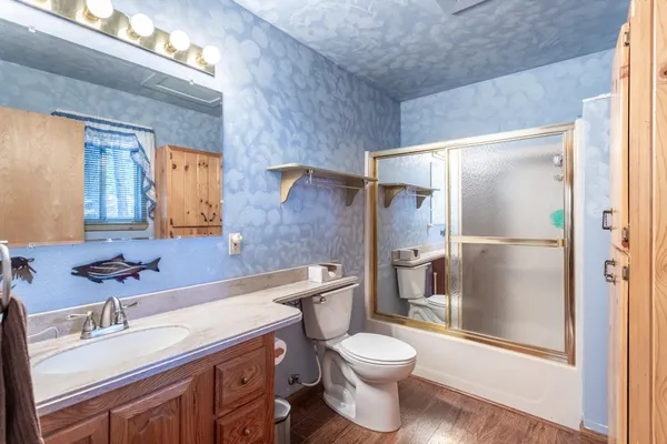 a bathroom with a granite countertop sink toilet and shower