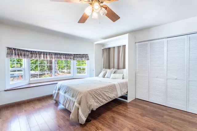 a bedroom with a bed and a large window