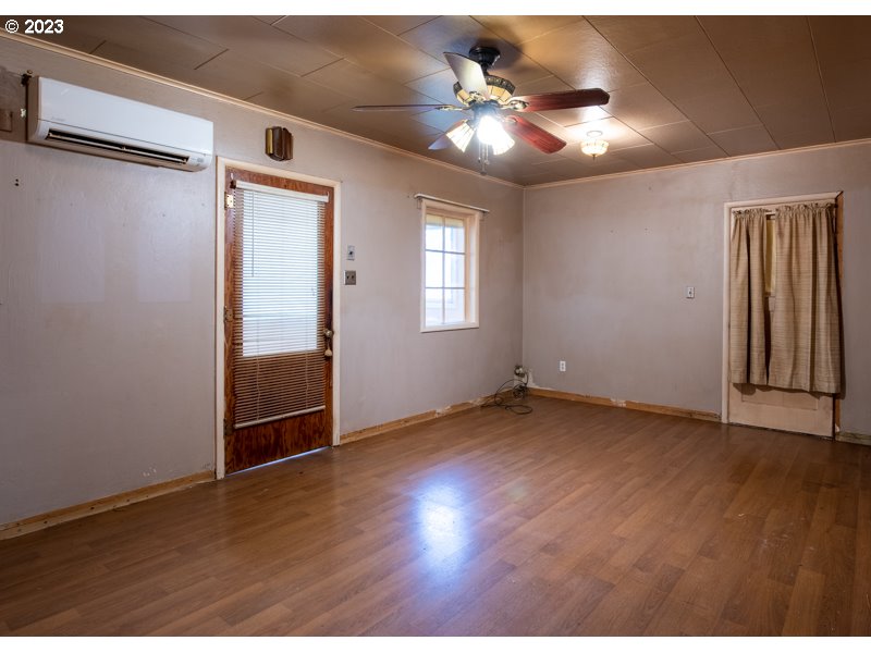 1225 E Street Springfield, OR 97477 - Photo 7 of 25 an empty room with wooden floor chandelier fan and windows