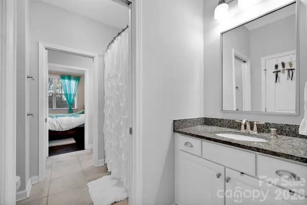 a en suite bathroom with a granite countertop sink and a mirror