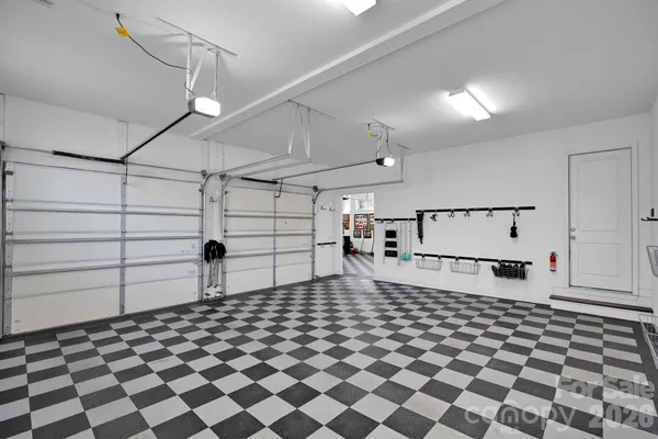 a living room with a black white checkered floor with couches and a fireplace