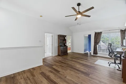 a view of a kitchen with wooden floor and a ceiling fan