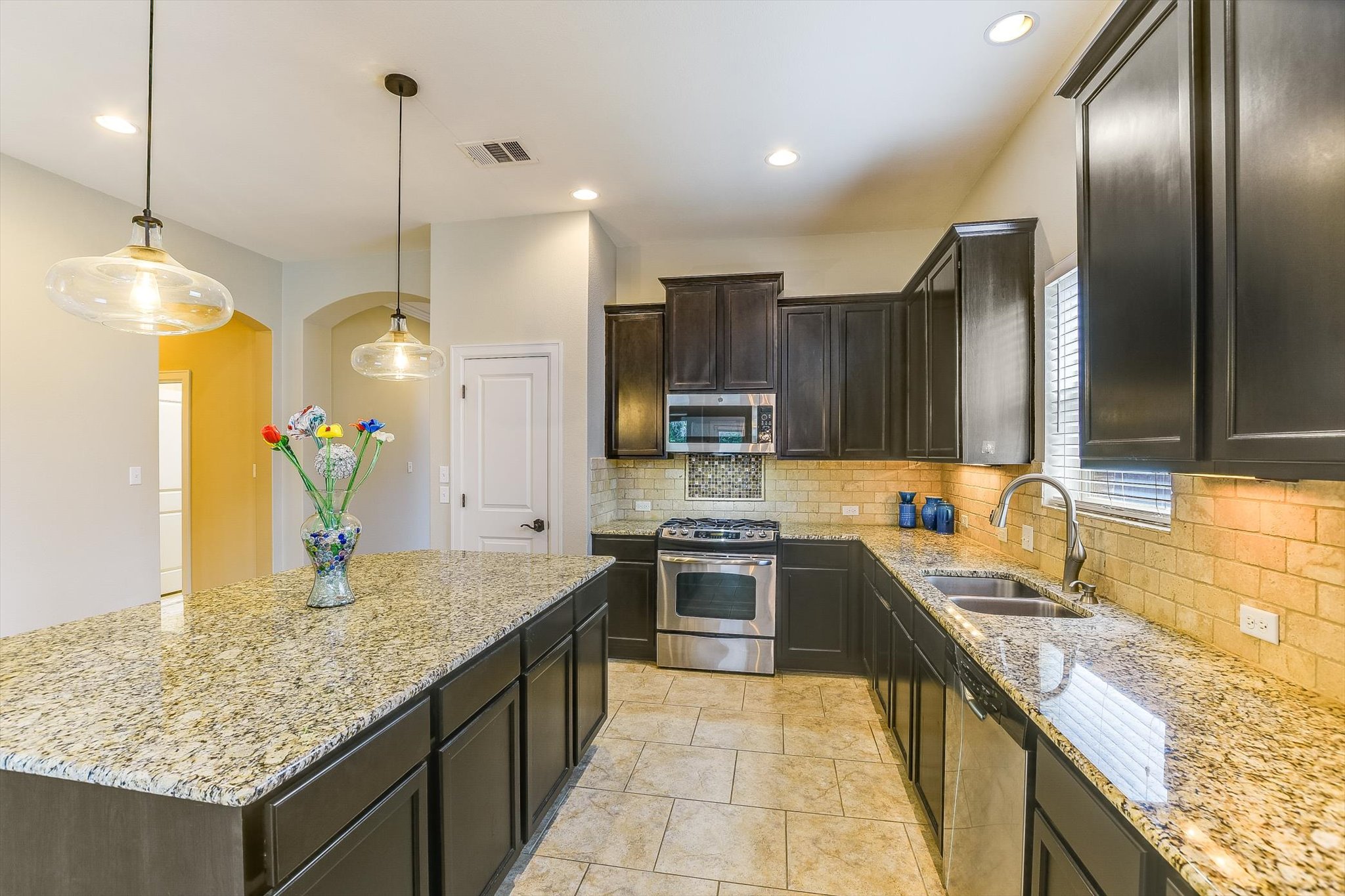 203 Gaspar Bend Cedar Park, TX 78613 - Photo 5 of 20 a kitchen with stainless steel appliances granite countertop a sink counter space cabinets and wooden floor