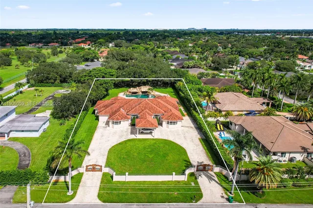an aerial view of residential houses with outdoor space and trees