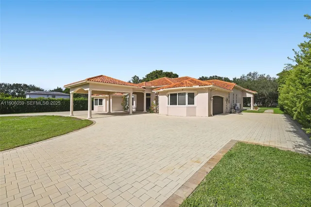 a front view of a house with yard and green space