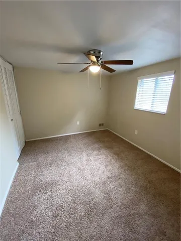 en empty room with windows and fan