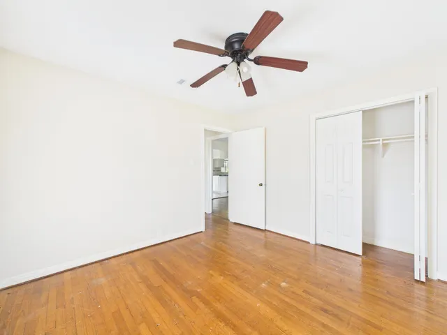 a view of a room with wooden floor and a ceiling fan