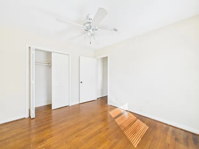 a view of an empty room with a window and a ceiling fan