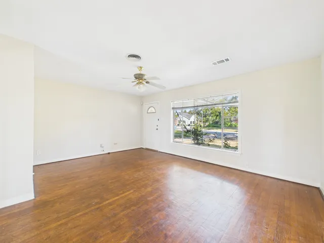 an empty room with fan and windows