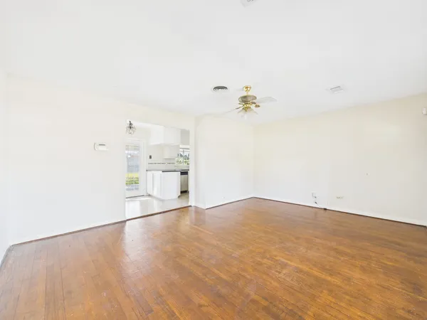 a view of an empty room with wooden floor