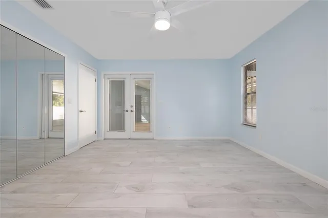 a view of an empty room with window and wooden floor