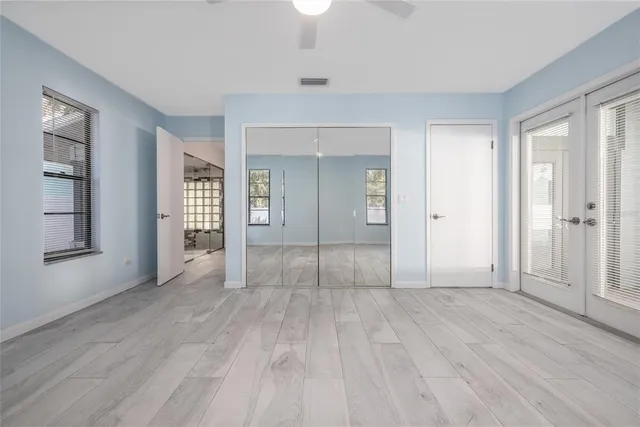 a view of empty room with wooden floor and fan