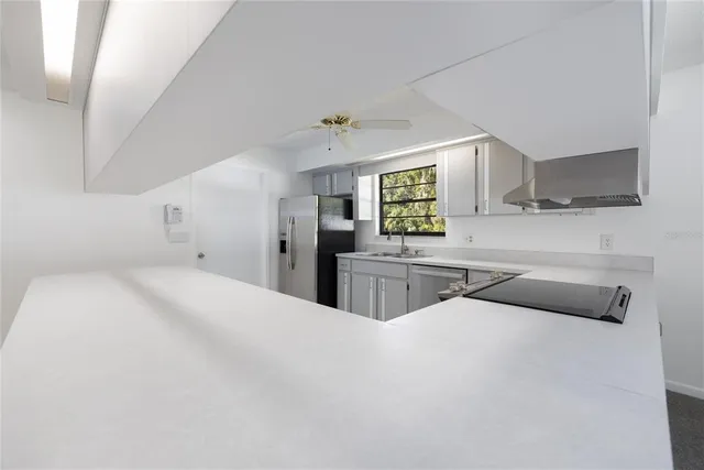 a kitchen with white cabinets and sink