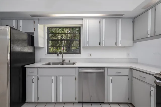 a kitchen with a sink cabinets appliances and a window