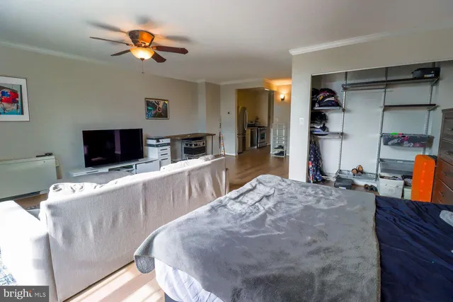 a living room with stainless steel appliances furniture and a flat screen tv