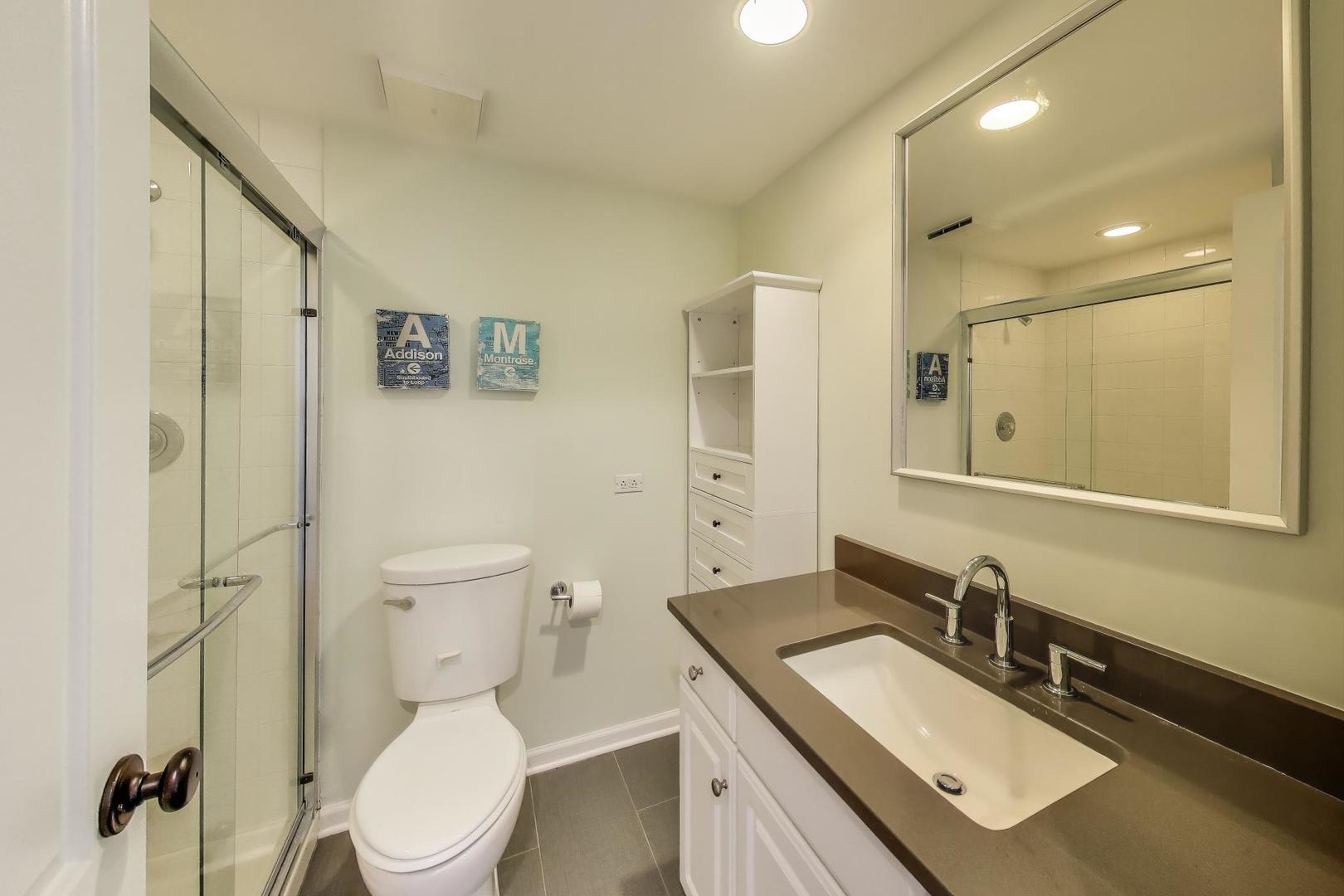 1862 North Halsted Street, Unit 3N Chicago, IL 60614 - Photo 19 of 25 a bathroom with a granite countertop toilet sink and mirror
