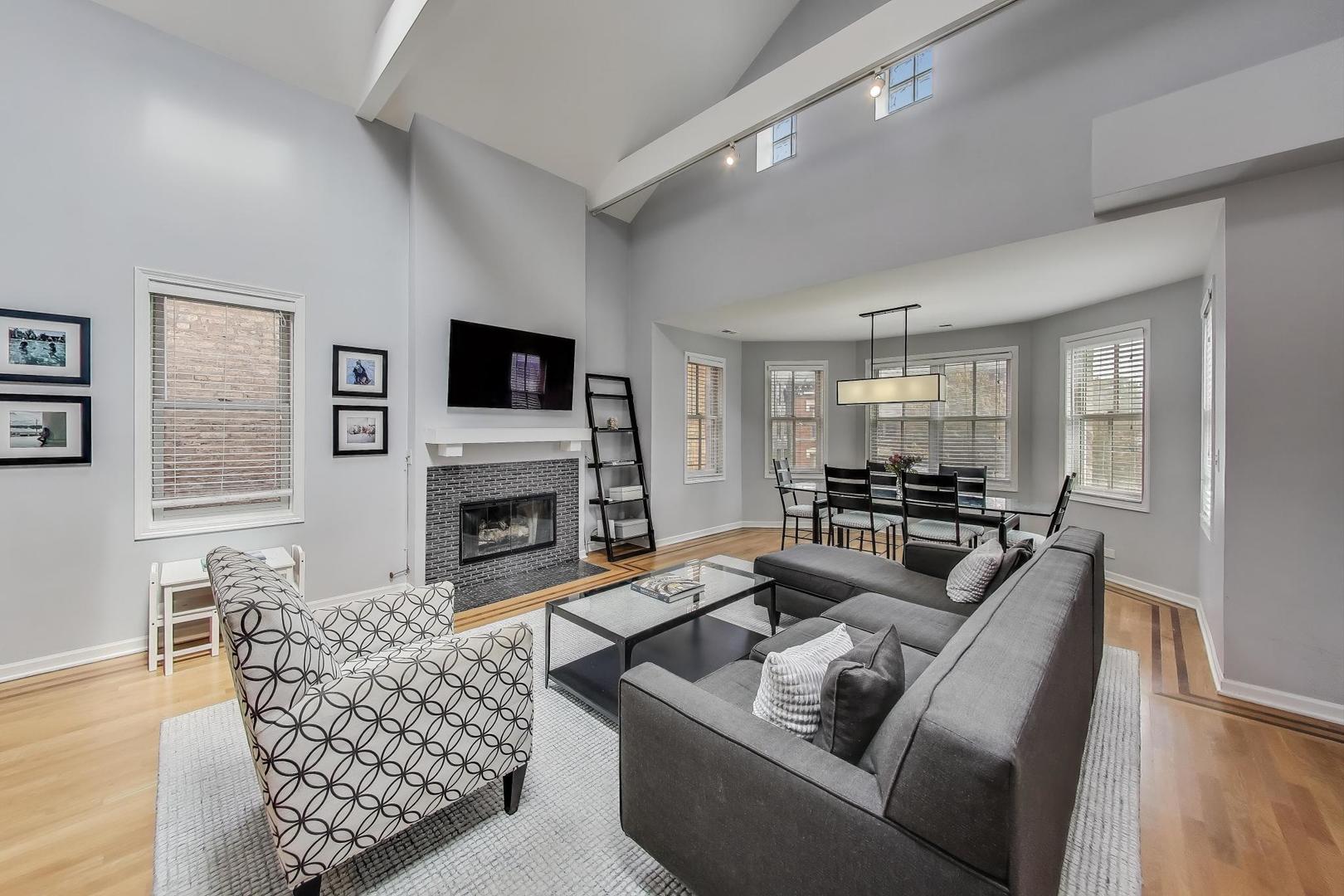 1862 North Halsted Street, Unit 3N Chicago, IL 60614 - Photo 3 of 25 a living room with furniture a fireplace and a flat screen tv