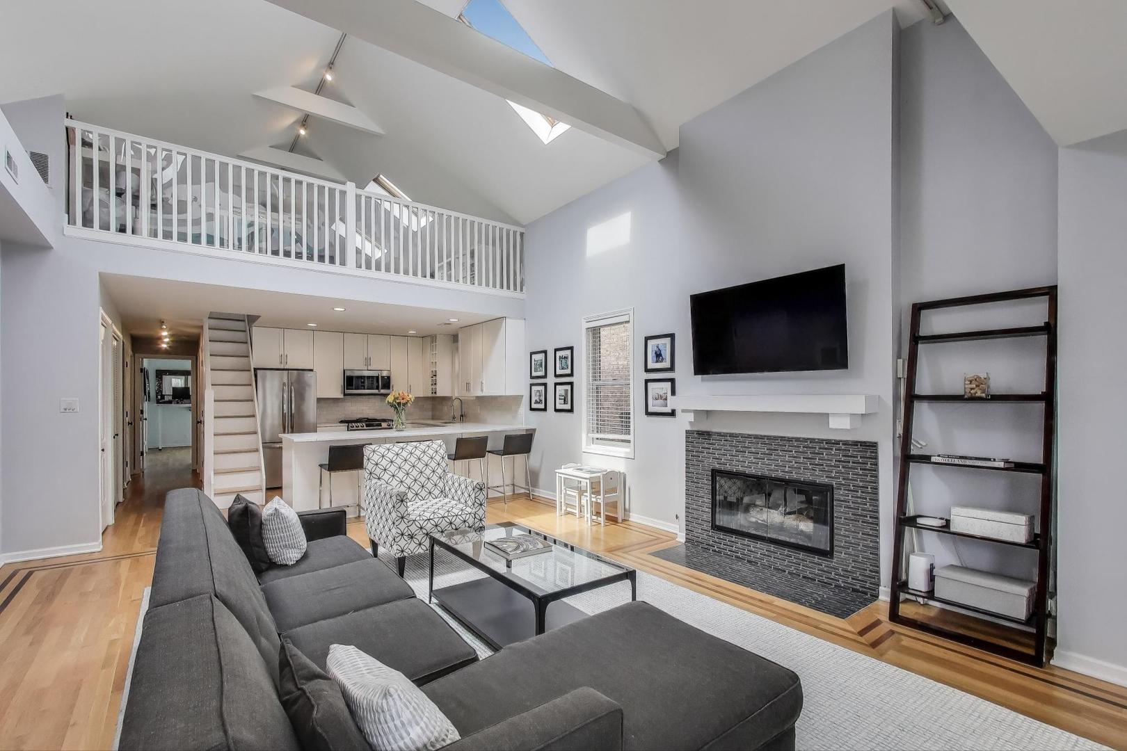 1862 North Halsted Street, Unit 3N Chicago, IL 60614 - Photo 4 of 25 a living room with furniture a flat screen tv and a fireplace