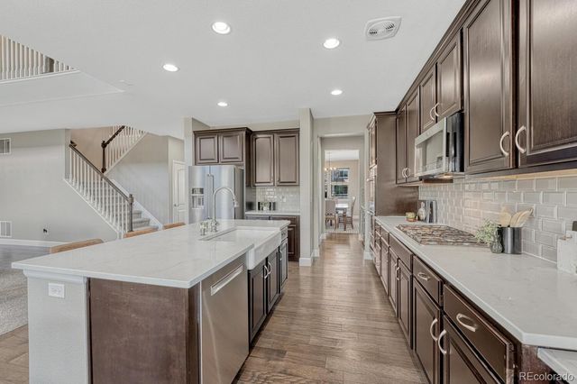 a kitchen with stainless steel appliances granite countertop a sink a stove and a refrigerator