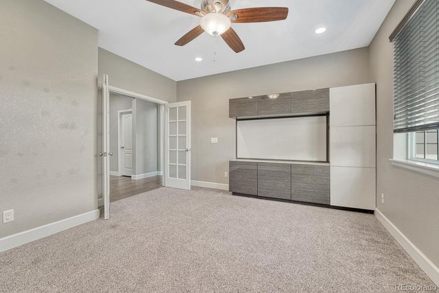 an empty room with fan and windows