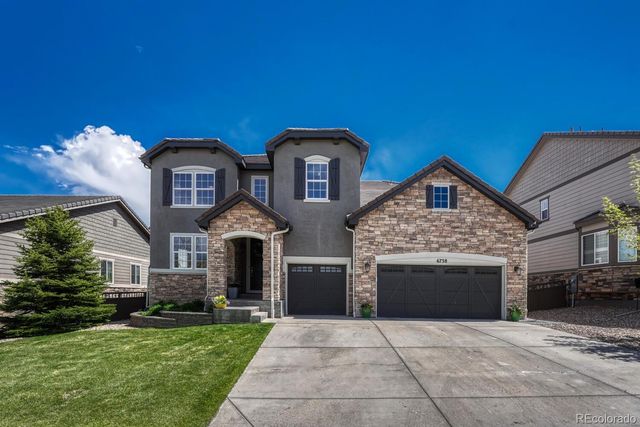 a front view of a house with yard and parking