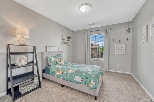 a bedroom with a bed and a lamp on the dresser