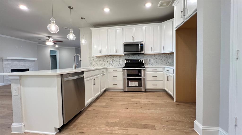 651 Watters Road, Unit 3300 Allen, TX 75013 - Photo 10 of 25 Kitchen with tasteful backsplash, kitchen peninsula, ceiling fan, appliances with stainless steel finishes, and light hardwood / wood-style floors