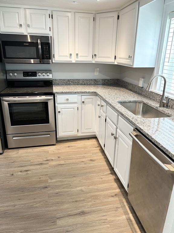 13 Maranook Road Worcester, MA 01606 - Photo 18 of 24 a kitchen with granite countertop a stove oven and white cabinets