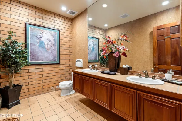 a bathroom with a granite countertop sink toilet a mirror and shower