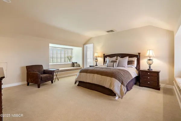 a bed room with a bed and a chair