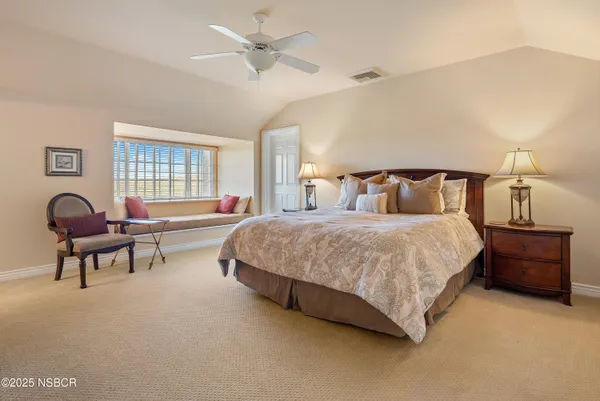 a bedroom with a bed a couch and dresser