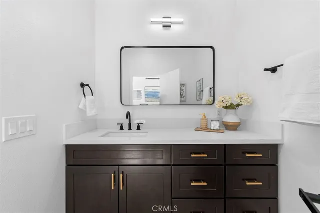 a bathroom with a sink vanity and a mirror