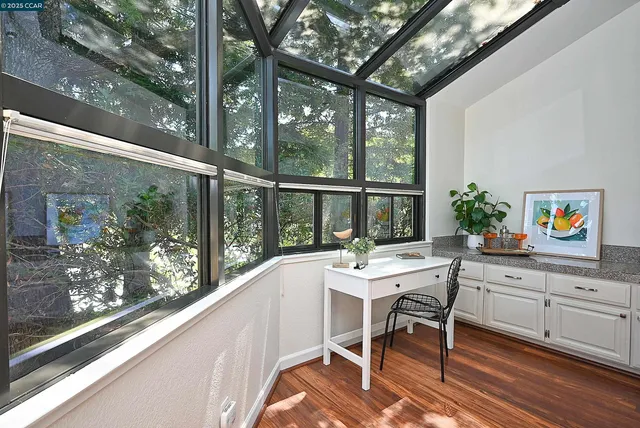 a view of a dining room with furniture large windows and wooden floor
