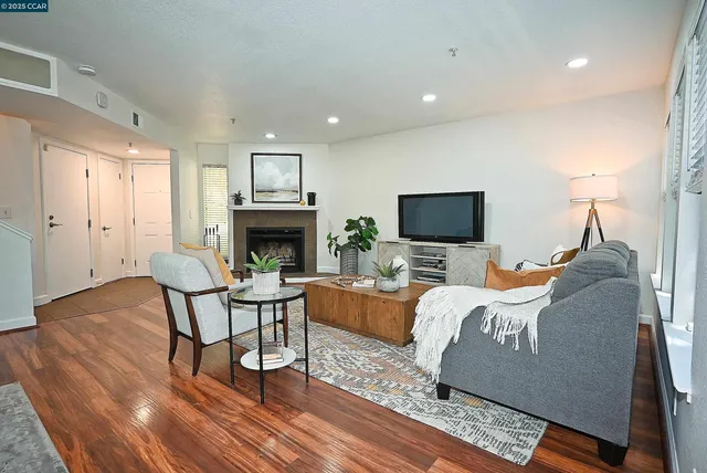 a living room with furniture a fireplace and a flat screen tv