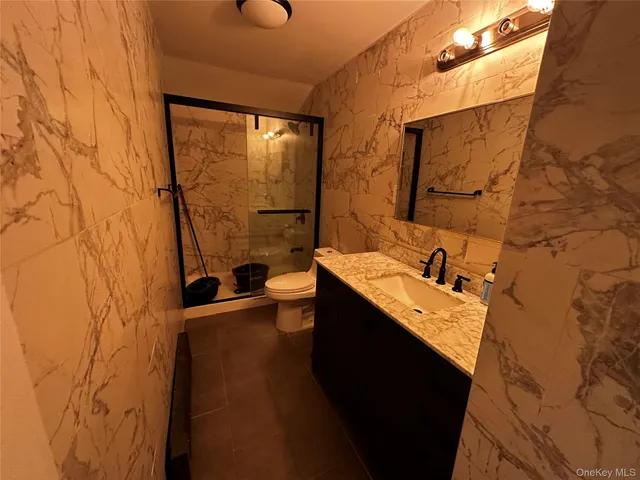 a bathroom with a sink and mirror with bathtub